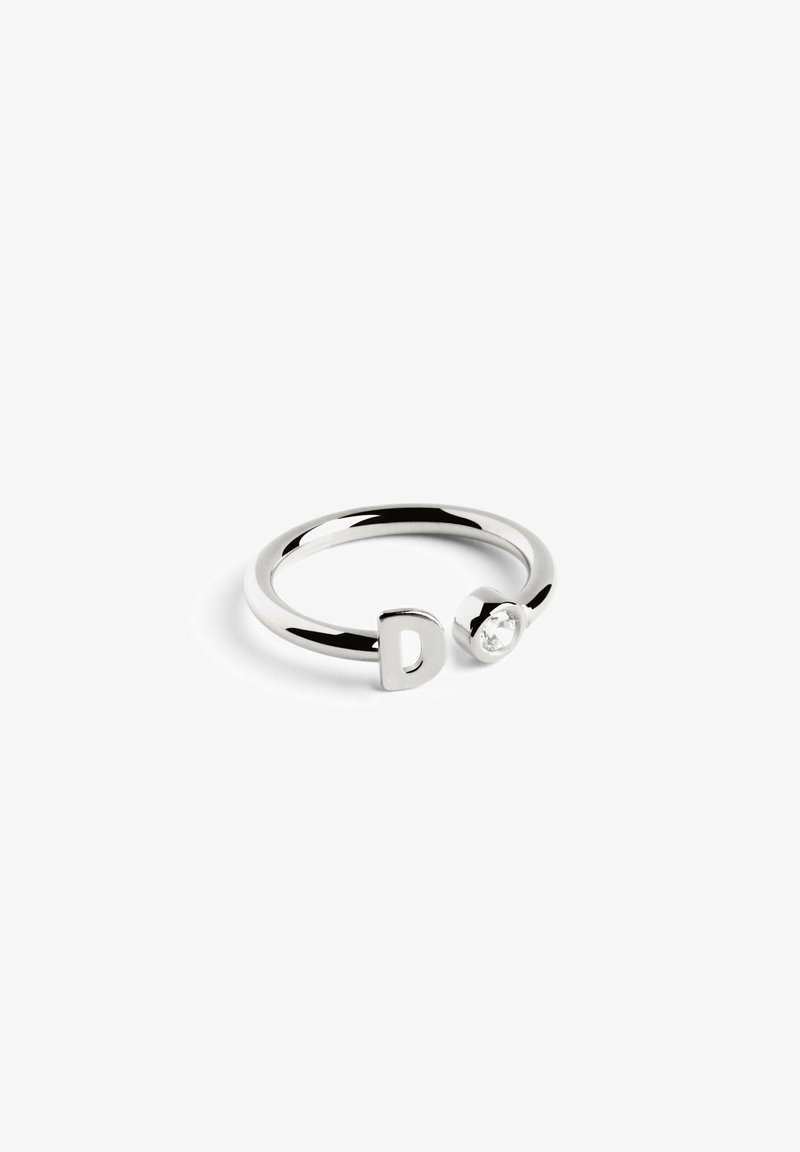 Anello in metallo argento con design a "D" e accento di pietra chiara rotonda; superficie elegante e liscia con finitura lucida.