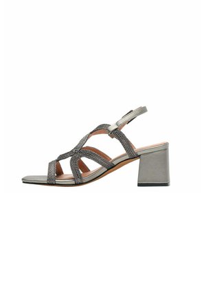 Sandalo da donna con tacco a blocco in argento metallizzato, cinturini intrecciati e fibbia regolabile alla caviglia, design con punta aperta.