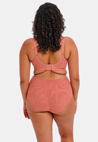 Rosa Bikini-Oberteil mit verstellbaren Trägern und Verschluss, kombiniert mit hoch taillierten Bikini-Unterteilen. Glatte Textur, minimales Design, vollständige Abdeckung.