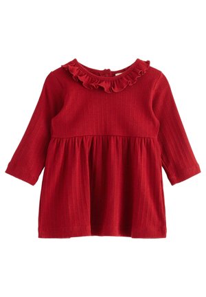 Robe bébé rouge à manches longues avec texture côtelée, taille froncée et col à volants sur un fond blanc.