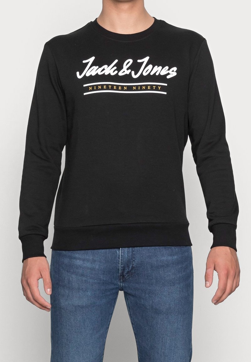 Sudadera negra de algodón, con cuello redondo, mangas largas y texto blanco con un detalle gráfico "Jack & Jones Nineteen Ninety."
