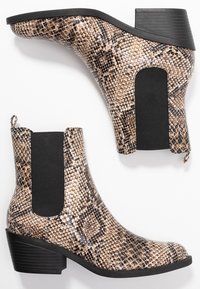 Bottines à motif serpent marron et noir avec panneaux élastiques noirs sur les côtés et talons épais.