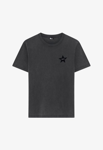 Camiseta de manga corta en gris carbón, con cuello redondo, adornada con una pequeña estrella negra y el texto blanco "TE RETO A QUE ME HAGAS" en el lado izquierdo del pecho.