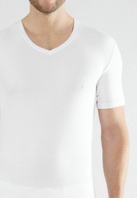 Witte t-shirt met korte mouwen en een V-hals, gemaakt van gladde, rekbare stof, met een aansluitend ontwerp en strakke, minimalistische naden.