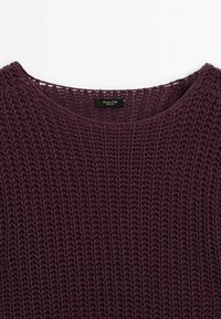 Sweter dziany w głębokim odcieniu fioletu z fakturowanym, otwartym splotem, z zaokrąglonym dekoltem i widoczną metką wewnątrz.