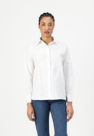 White long-sleeve shirt with a button-up front, featuring a subtle tonal script pattern, complemented by a classic collar and smooth texture.