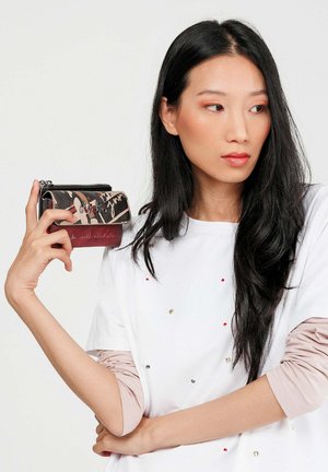 Portafoglio in una combinazione di nero e marrone, con motivi a scrittura e finitura texturizzata, dotato di una cerniera metallica e accenti rossi a contrasto.