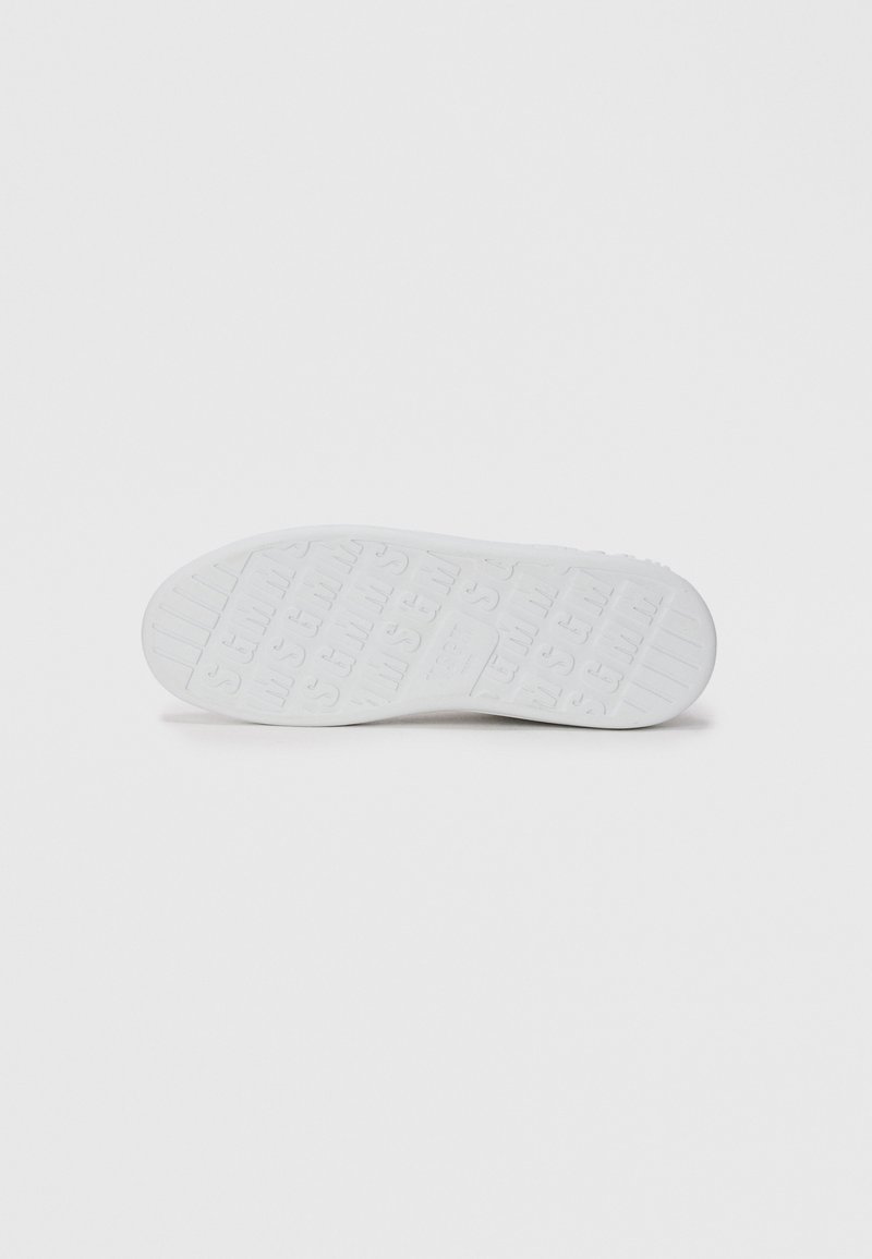Semelle de sneaker blanche avec un motif de semelle, présentant des lignes horizontales et du texte surélevé répété sur un fond clair.