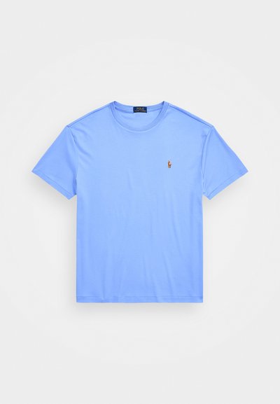 T-shirt azul claro de manga curta feita de algodão. Possui um decote arredondado e um pequeno logótipo bordado no lado esquerdo do peito. Textura suave.