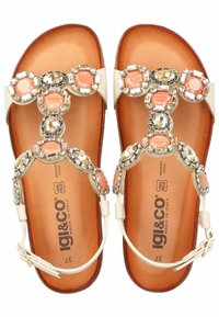 Sandali piatti con cinghie beige, decorati con pietre trasparenti e color pescato. Suola imbottita marrone, con il marchio "IGI&CO".