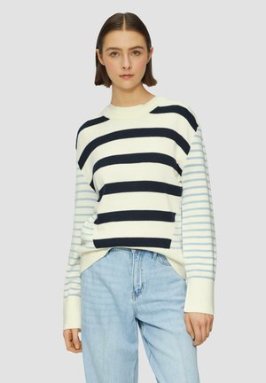 Katoenen sweater met marineblauwe en lichtblauwe strepen, ribgebreide halslijn en een losse pasvorm. Gecombineerd met lichtblauwe jeans.