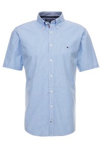 Camicia a maniche corte con bottoni di colore azzurro chiaro, con un motivo a quadretti. Presenta un colletto classico e un logo sul lato sinistro del petto.