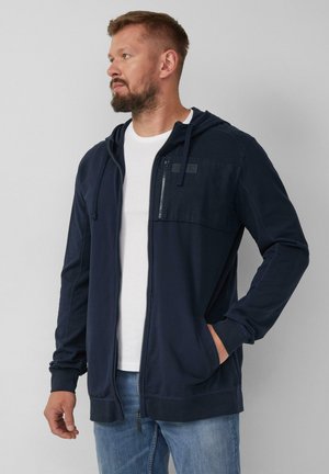 Marineblauer Reißverschluss-Hoodie mit strukturiertem Brustpaneel, verstellbarem Kapuzenzug und Seitentaschen. Hergestellt aus weichem Stoff mit kontrastierenden Nähten.