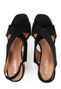 Zwarte suede sandalen met een vierkante teen, crisscross bandontwerp, open zijkanten en een tan inlegzool met de merknaam "Findlay."