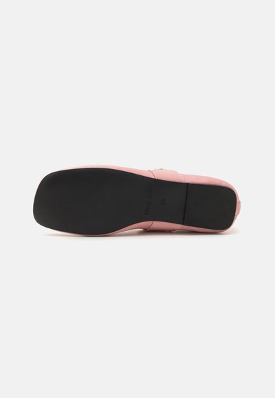 Sandal de cuero rosa con suela plana, que presenta una base de goma negra. El diseño incluye una sola correa y detalles de costura minimalistas.