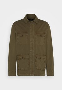 Chaqueta verde oliva con cierre de botones en la parte delantera, cuello con solapa y cuatro bolsillos frontales. Fabricada con un tejido duradero y de textura suave.