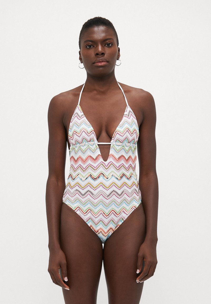 Costume da bagno intero con un colorato motivo a zigzag, scollatura a V, spalline a collare e gambe alte, realizzato in un materiale leggero.