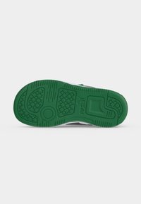 Το πέλμα ενός sneaker Puma με πράσινη σόλα που δείχνει υφασμένα σχέδια πέλματος και το λογότυπο Puma στο κέντρο.
