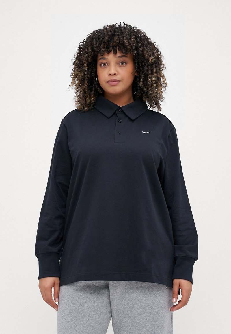 Polo noir à manches longues en tissu doux, avec un col, une patte de boutonnage et un petit logo blanc sur la poitrine.
