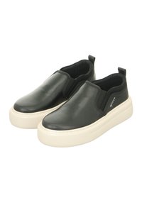 Black slip-on shoes with a smooth leather upper, elastic side panels, and a thick cream-colored rubber sole featuring a textured surface.