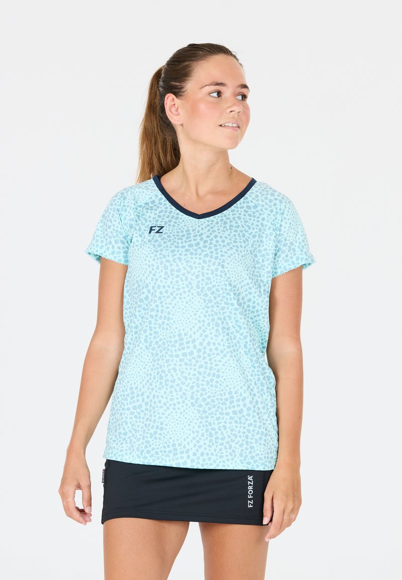 Ljusblå träningsskjorta med leopardmönster, korta ärmar och marinblå v-ringad krage. Varumärkeslogotyp synlig fram.