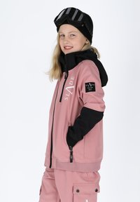Lyserød og sort isoleret jakke med lynlåslukning, stor hætte, logo på brystet og sidelommer. Begge dele ledsages af sorte skibriller.
