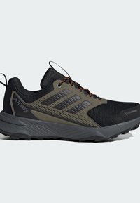 Schwarzer Terrex Wanderschuh mit atmungsaktivem Mesh-Obermaterial und grünen Akzenten, verfügt über strukturierte Überzüge, orangefarbene Schnürsenkel und eine robuste Gummisohle.