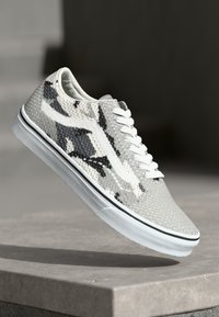 Gray and white sneaker with a textured mesh upper, black accents, laces, and a white rubber sole featuring a black stripe.