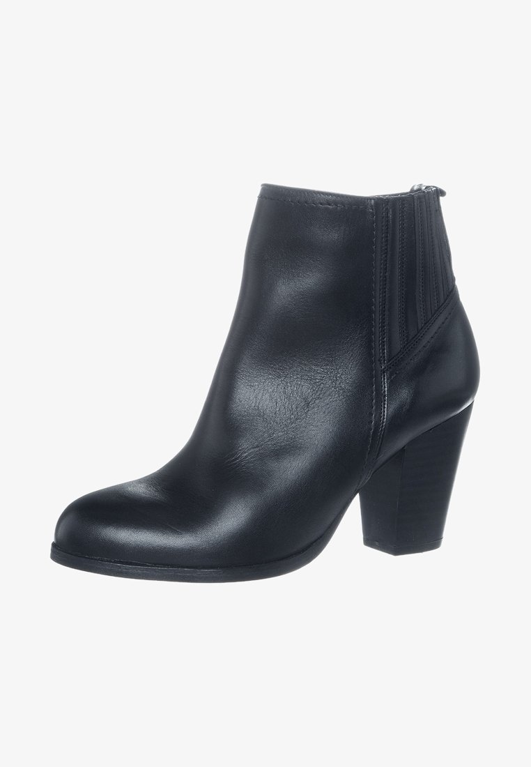 Bottine en cuir noir avec talon carré et empiècement latéral élastique, conçue pour la mode féminine et le port décontracté.