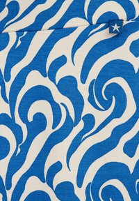 Zils un balts audums ar vijīgām rakstu līnijām, kurās ir dažādas zila toņu nianses uz krēmkrāsas fona. Iekļauts neliels zils birkas uzraksts ar zvaigzni.