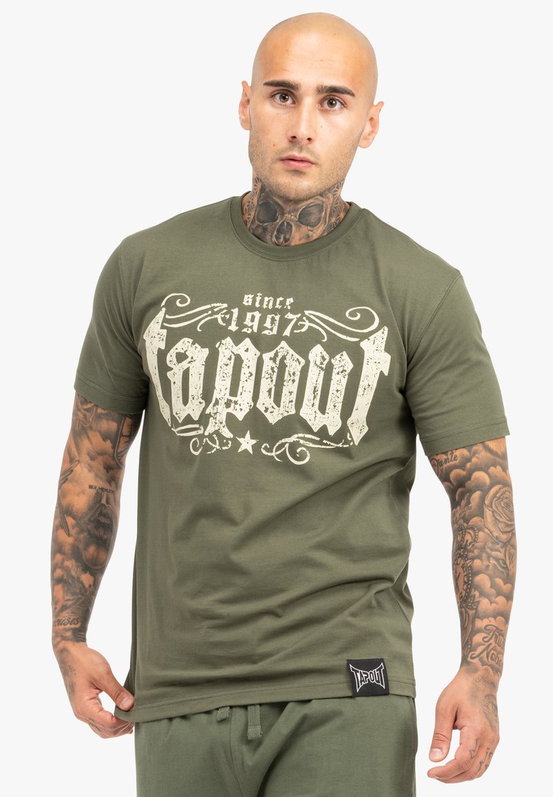 Olive zelené bavlnené tričko so starožitnou bielou grafikou "Tapout", klasickým okrúhlym výstrihom a malou čiernou etiketou na leme.