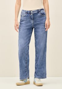 Ljusblå vida jeans i denim med en blekt tvätt, två framfickor och en dragkedja med två knappar.