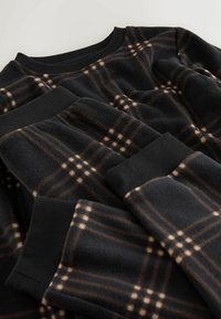 Czarny polarowy sweter w kratę w odcieniach brązu i beżu, z żebrowanymi mankietami i dekoltem. Miękka tekstura z warstwowym wyglądem.