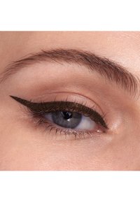 Nahaufnahme eines Auges, das einen auffälligen schwarzen Eyeliner mit verlängertem, geschwungenem Design zeigt. Die Iris ist blau mit subtilen Sprenkeln, und die Haut hat eine glatte Textur.