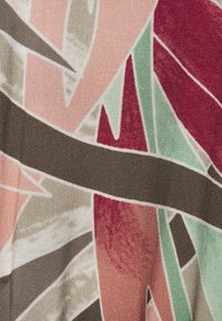 Textile featuring abstract design in shades of pink, green, brown, and red, with smooth texture and geometric shapes.