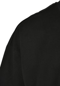 Svart T-skjorte i en myk bomullsblanding, med en avslappet passform, rund hals og korte ermer. Subtil tekstur uten synlige mønstre eller detaljer.