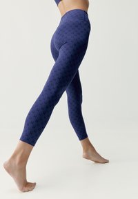 Navy leggings, joissa on toistuva pieni musta kuvio, korkea vyötärö ja sileä, joustava rakenne, suunniteltu mukavuutta ja liikkuvuutta varten.