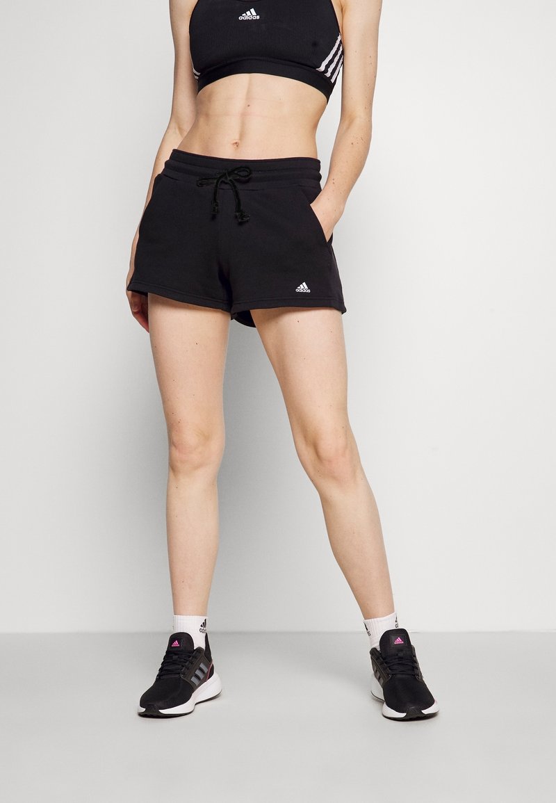 Svarta träningsshorts i en blandning av bomull, med elastisk midja och dragsko. Adidas-logotypen är synligt placerad på vänster ben.