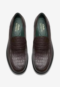 Mørkebrune læderloafers med krokodillemønster, der har en glat finish, rund form og grønne polstrede indlægssåler.