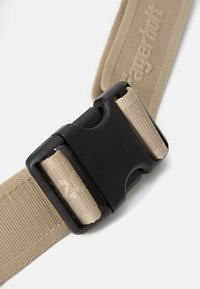 Rudas nailonas diržas su juodu plastiko sagtimi. Tekstūruotas paviršius su siuvinėtomis detalėmis. Turi saugų, reguliuojamą užsegimą.