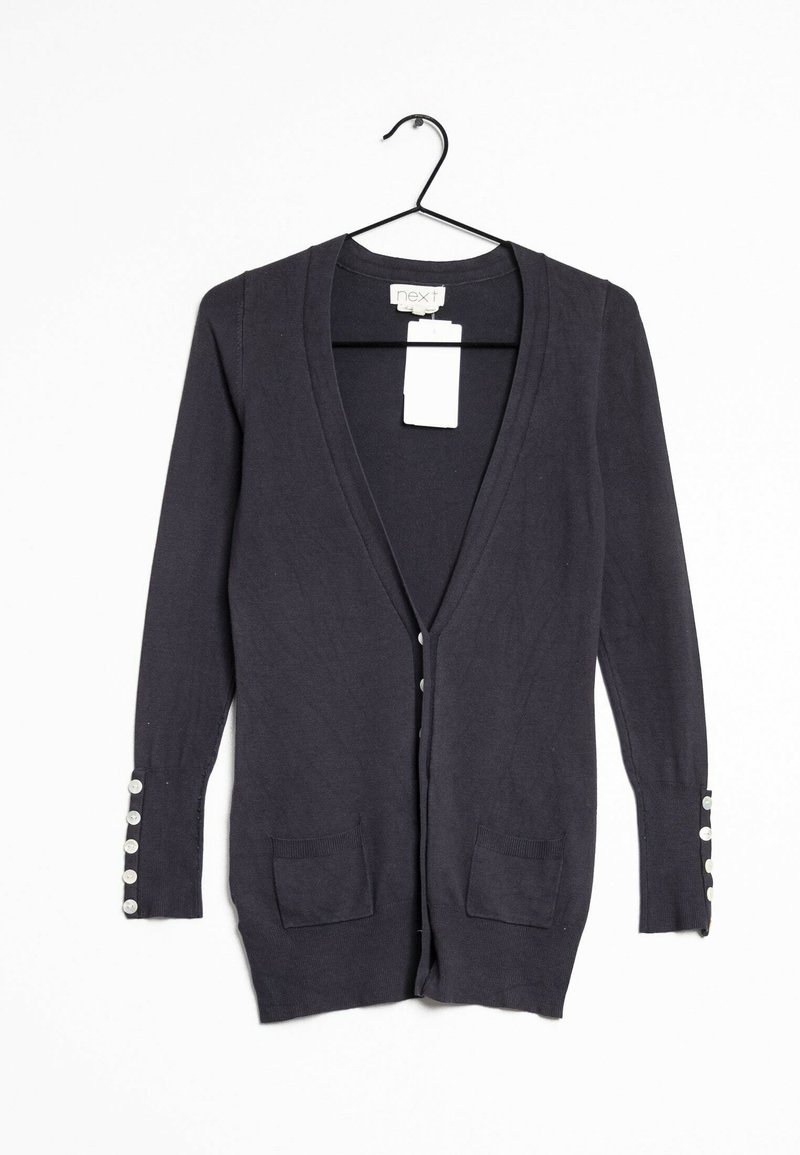 Dunkelblauer Cardigan mit langen Ärmeln, V-Ausschnitt, zwei Fronttaschen und Knopfdetails an den Bündchen. Aus weichem Strickstoff gefertigt.