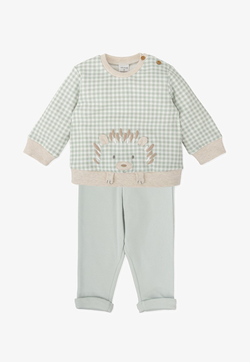 Sudadera de cuadros en verde claro con un aplique de erizo y detalles en beige, combinada con pantalones azul claro de puños enrollados. Material de algodón suave.