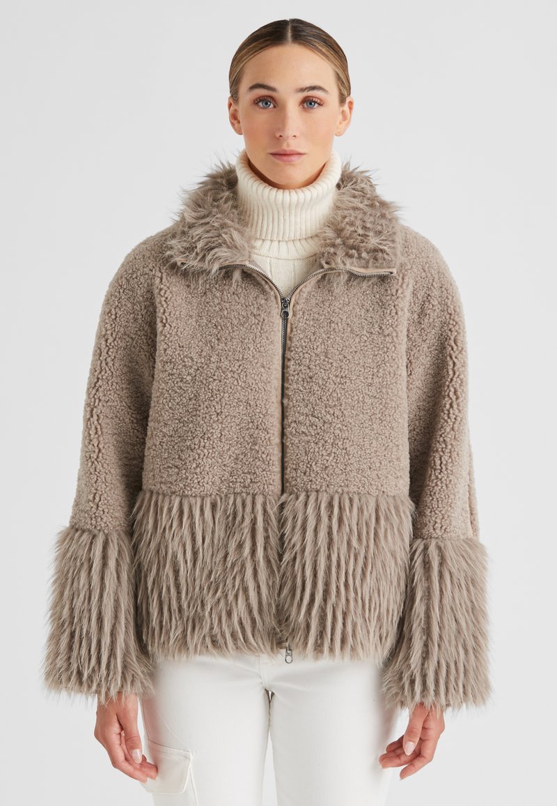 Faux-Fur-Jacke in Taupe mit einem strukturierten Körper, einem flauschigen Kragen und langen Pelzärmeln. Verfügt über einen Frontreißverschluss und einen lässigen Schnitt.