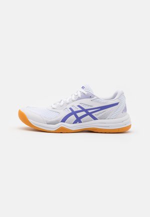 Weißer Sportschuh mit blauem Logo und oranger Sohle, seitlich auf neutralem Hintergrund betrachtet.