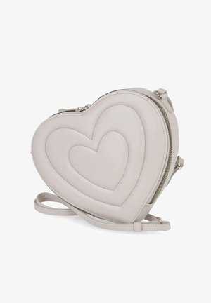 Kleine lichtgrijze crossbodytas in hartvorm met gestikt hartpatroon en ritssluiting, dunne verstelbare riem ligt aan de voorkant.