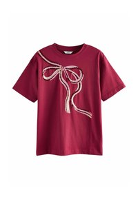 Bordeaux bomullst-shirt med en paljetterad rosettdesign i rosa och röda nyanser på vänster sida. Klassisk rund halsringning och korta ärmar.