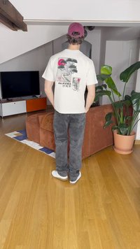 Hvit t-skjorte med et japansk inspirert grafisk design på baksiden, med et tre og en tiger. Brukt med grå jeans og hvite sko. Vinrød caps.