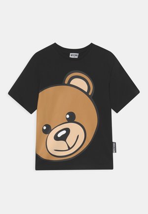Czarny t-shirt Moschino z dużą, uśmiechniętą brązową twarzą misia nadrukowaną z przodu.