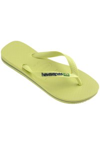 Šviesiai geltonos Havaianas šlepetės su tekstūruotu padu, Y formos dirželiais ir logotipu su Brazilijos vėliavos detale. Lygios formos, lengvos svorio.