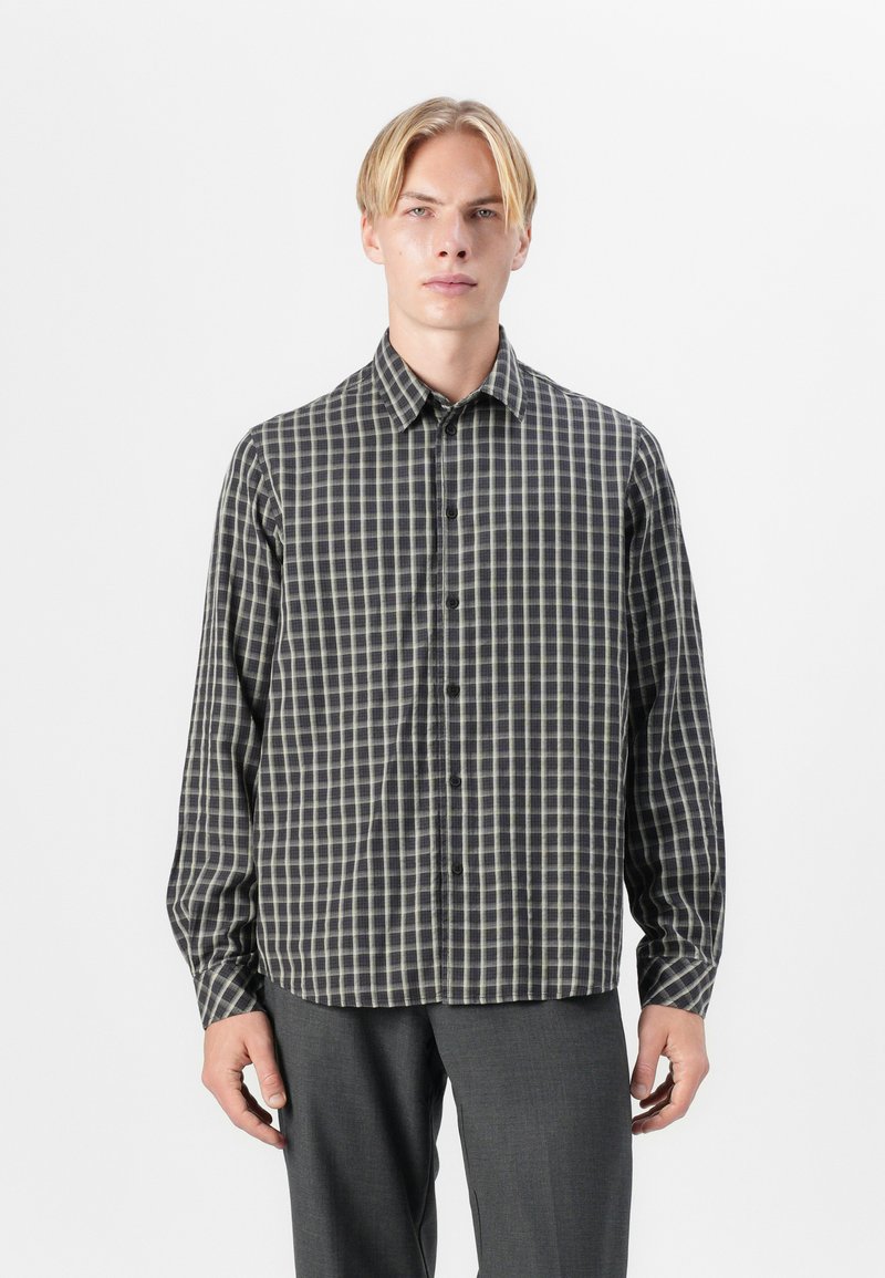 Langermet skjorte med knapper i et mørkegrått og kremfarget rutemønster. Myk stoff med klassisk krage og frontknapper.
